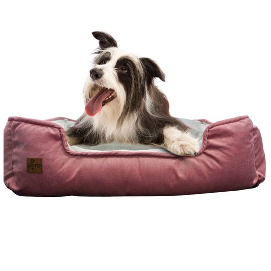 Perro mediano descansando en cama rectangular antirasguños de tela ovejera gris.