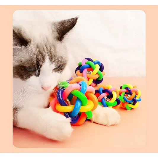 Gato jugando con pelota de goma nudo sonajero en el piso